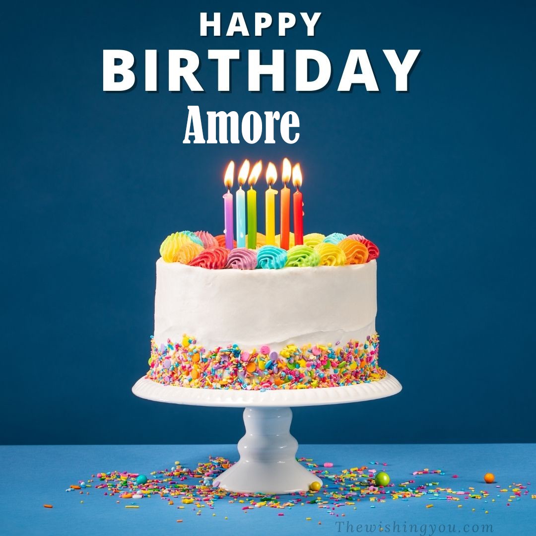Happy birthday Amore written on image White cake keep on White stand and burning candles Sky background