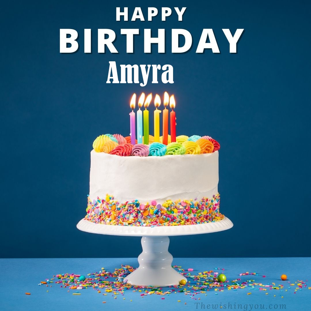 Happy birthday Amyra written on image White cake keep on White stand and burning candles Sky background