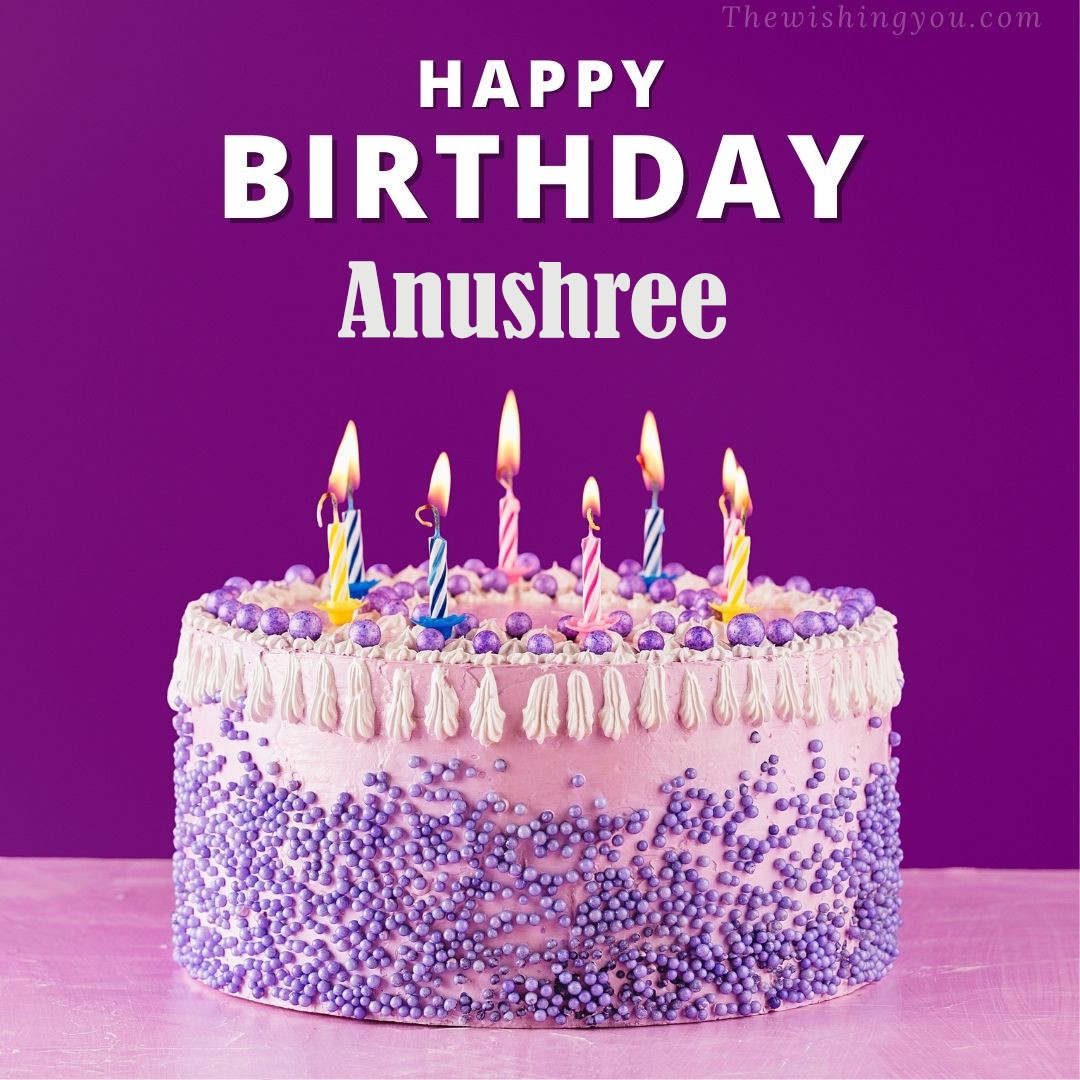 Happy birthday Anushree written on image White and blue cake and burning candles Violet background