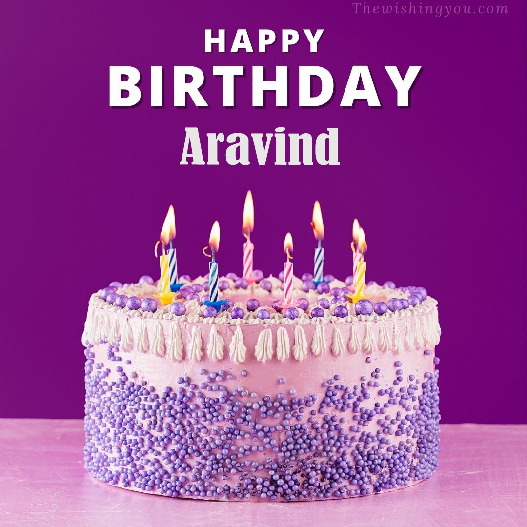 Happy birthday Aravind written on image White and blue cake and burning candles Violet background
