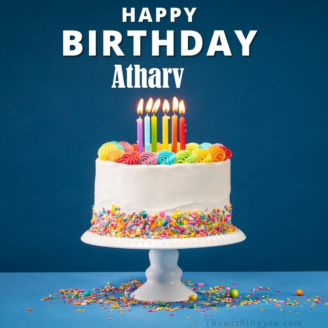 Happy birthday Atharv written on image White cake keep on White stand and burning candles Sky background
