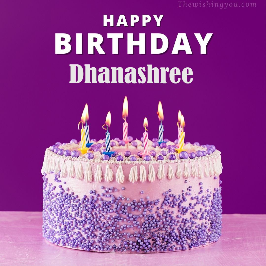 Happy birthday Dhanashree written on image White and blue cake and burning candles Violet background
