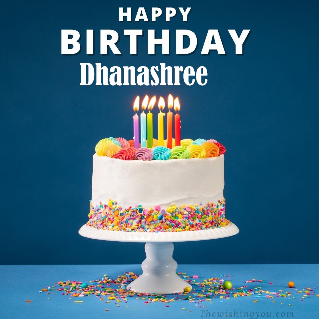 Happy birthday Dhanashree written on image White cake keep on White stand and burning candles Sky background