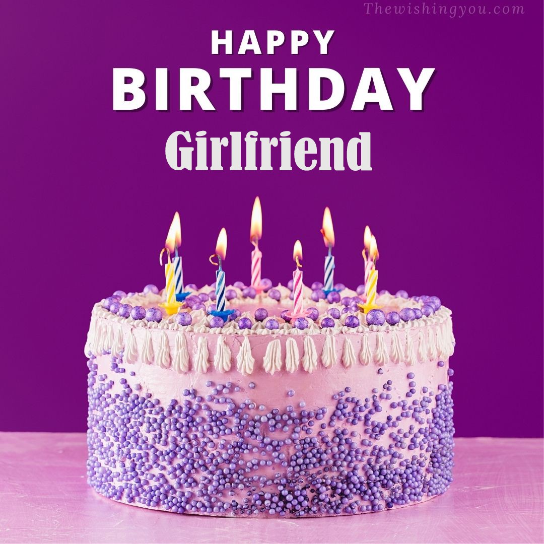 Happy birthday Girlfriend written on image White and blue cake and burning candles Violet background
