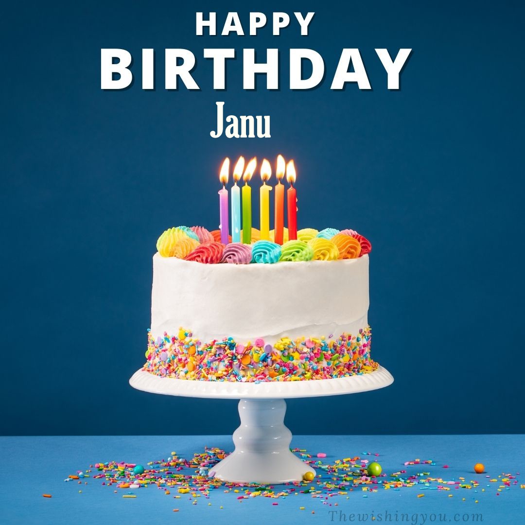 Happy birthday Janu written on image White cake keep on White stand and burning candles Sky background