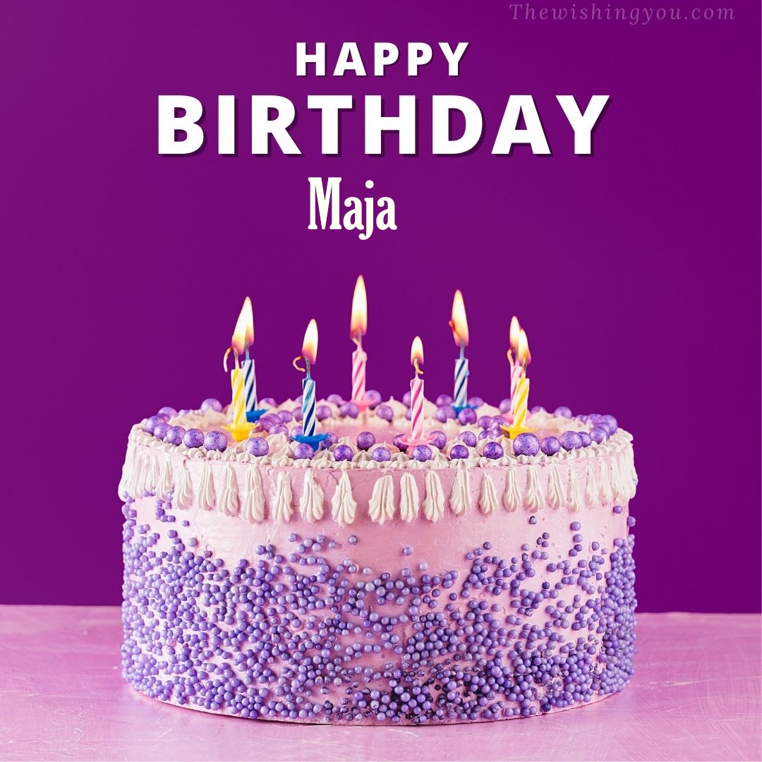 Happy birthday Maja written on image White and blue cake and burning candles Violet background