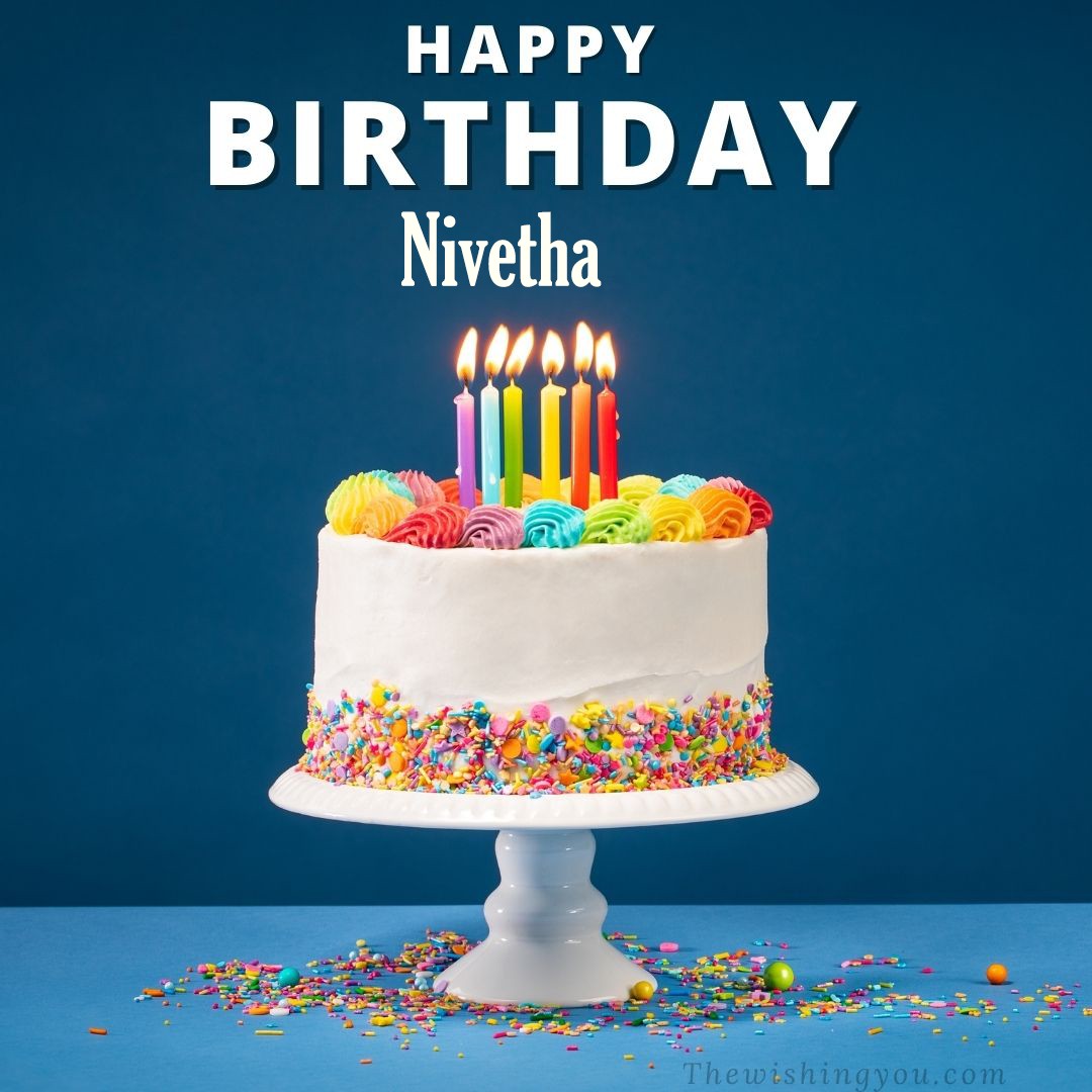 Happy birthday Nivetha written on image White cake keep on White stand and burning candles Sky background